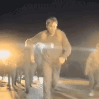 A Blurry Picture Of A Man Carrying A Person In A Wheelchair At Night . GIF