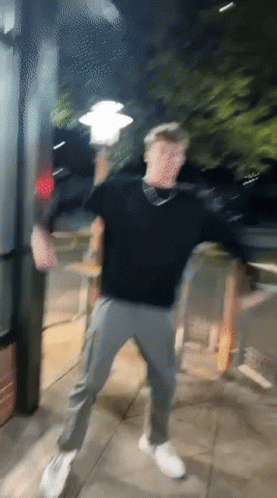 A Blurry Picture Of A Man Dancing On The Sidewalk GIF