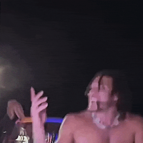 A Blurry Picture Of A Man Dancing With A Purple Light Behind Him GIF