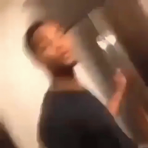 A Blurry Picture Of A Man Drinking From A Glass GIF