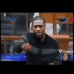 A Blurry Picture Of A Man Holding A Gun In Front Of A Sign That Says Viggle GIF