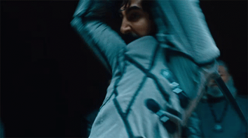 A Blurry Picture Of A Man Holding A Microphone With A Sticker On His Jacket That Says ' A ' On It GIF