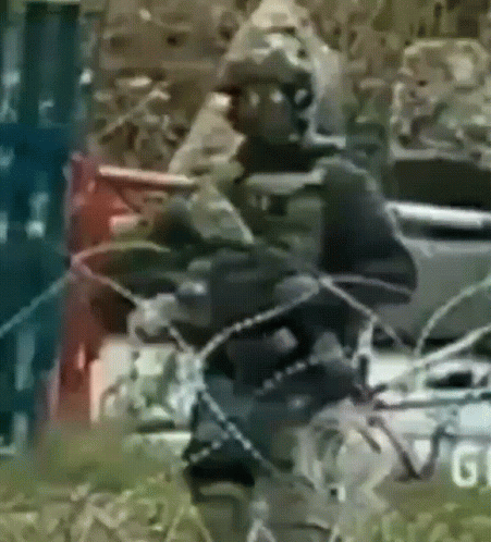 a blurry picture of a man holding a rifle with the word gi on the bottom