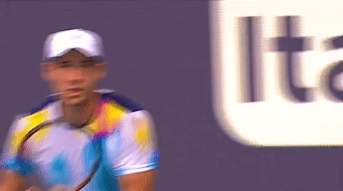 A Blurry Picture Of A Man Holding A Tennis Racquet In Front Of A Sign That Says Lite GIF