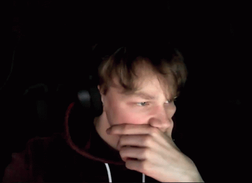 A Blurry Picture Of A Man Holding His Head With His Hands . GIF