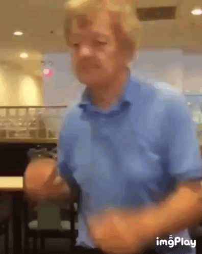 A Blurry Picture Of A Man In A Blue Shirt Dancing GIF