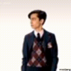 A Blurry Picture Of A Man In A Suit And Tie Standing In Front Of A White Background . GIF