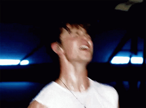A Blurry Picture Of A Man In A White Shirt Laughing . GIF