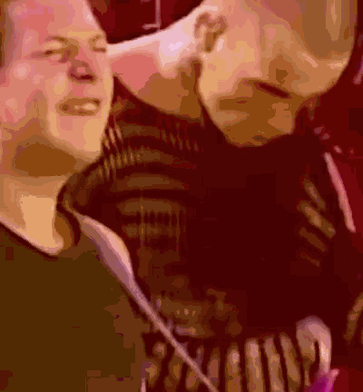 A Blurry Picture Of A Man Kissing Another Man 'S Neck GIF
