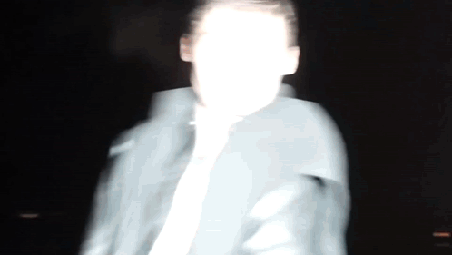 A Blurry Picture Of A Man 'S Face In The Dark GIF