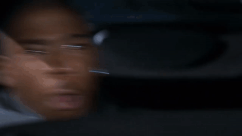 A Blurry Picture Of A Man 'S Face Looking Out A Car Window . GIF