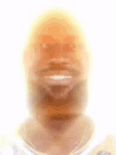 A Blurry Picture Of A Man 'S Face With A Yellow Hat On GIF