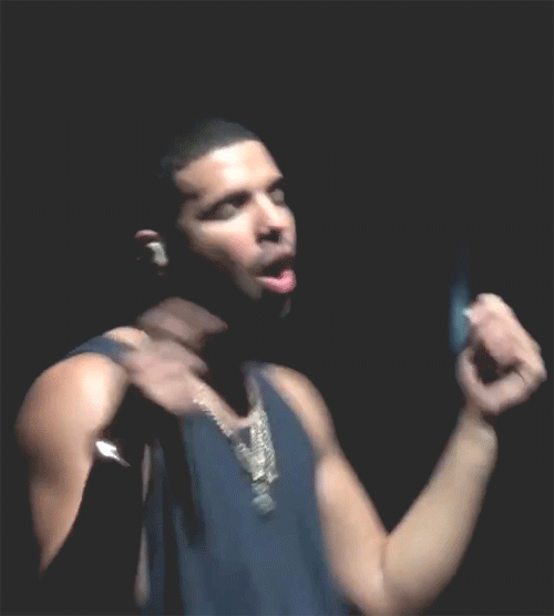 A Blurry Picture Of A Man Singing Into A Microphone In A Dark Room GIF