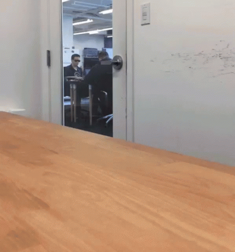 A Blurry Picture Of A Man Sitting In A Chair In A Room GIF