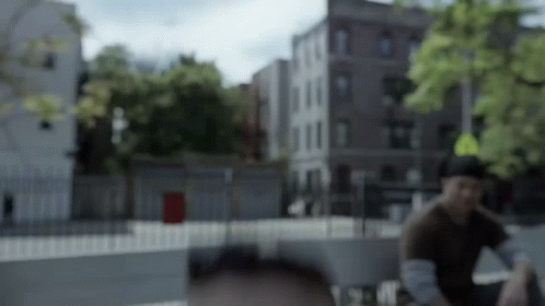 A Blurry Picture Of A Man Sitting In Front Of A Yellow Sign GIF