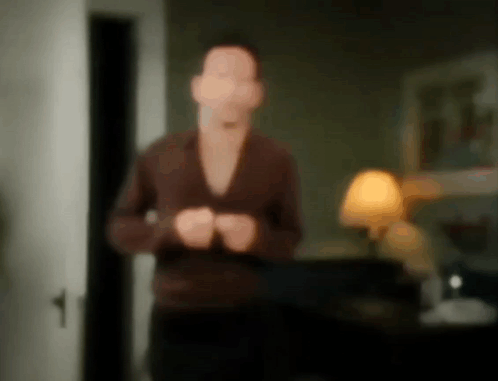 A Blurry Picture Of A Man Standing In A Living Room GIF