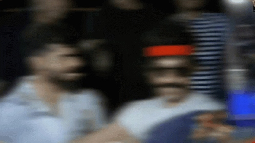 A Blurry Picture Of A Man Standing In Front Of A Red Light GIF