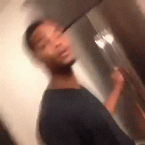 A Blurry Picture Of A Man Standing In Front Of A Refrigerator Holding A Fork . GIF