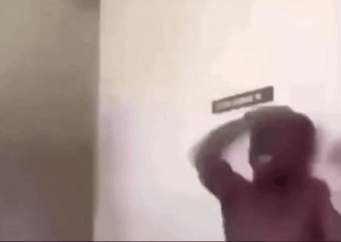 A Blurry Picture Of A Man Standing In Front Of A Sign That Says Smoking . GIF