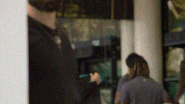 a blurry picture of a man standing in front of a window holding a cell phone .