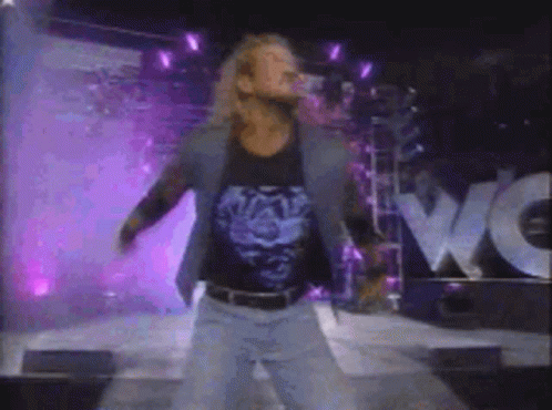 A Blurry Picture Of A Man Standing In Front Of A Wow Sign GIF