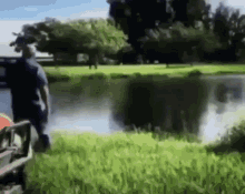 A Blurry Picture Of A Man Standing Next To A Body Of Water GIF