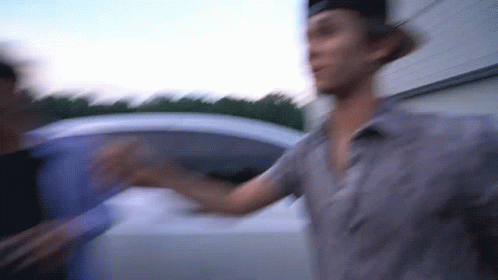 A Blurry Picture Of A Man Standing Next To Another Man GIF