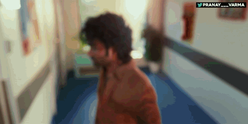 A Blurry Picture Of A Man Walking Down A Hallway With The Words Pranay Varma Written On The Bottom GIF