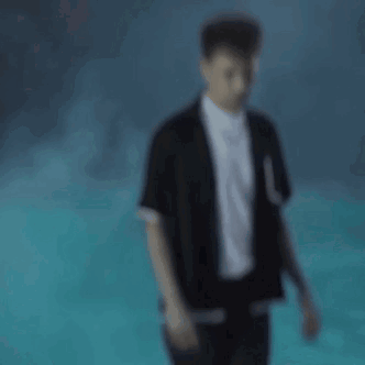 A Blurry Picture Of A Man Wearing A Black Jacket And White Shirt . GIF