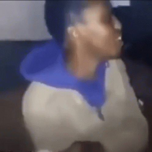 A Blurry Picture Of A Man Wearing A Blue Hoodie And A White Jacket . GIF