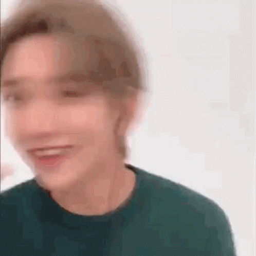 A Blurry Picture Of A Man Wearing A Green Sweater . GIF