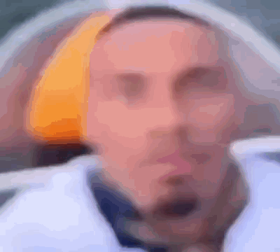 A Blurry Picture Of A Man Wearing A Hat And A Jacket . GIF