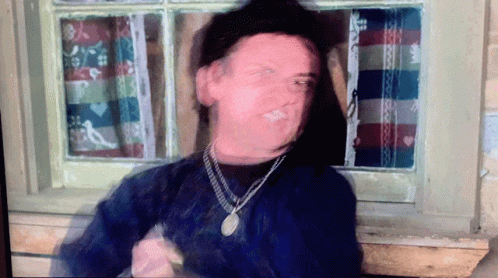 A Blurry Picture Of A Man Wearing A Necklace GIF