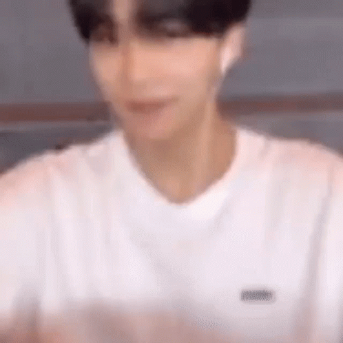 A Blurry Picture Of A Man Wearing A White T-Shirt . GIF