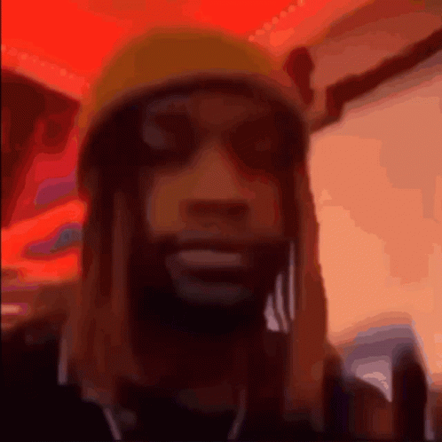 A Blurry Picture Of A Man Wearing A Yellow Beanie GIF