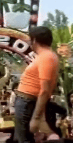 a blurry picture of a man wearing an orange shirt and a hat