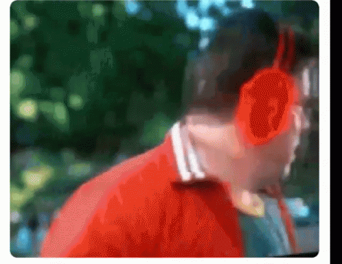 A Blurry Picture Of A Man Wearing Headphones And A Red Jacket GIF