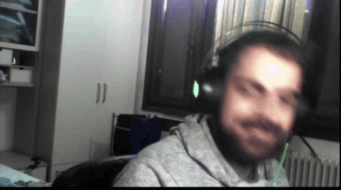 A Blurry Picture Of A Man Wearing Headphones In Front Of A Window GIF