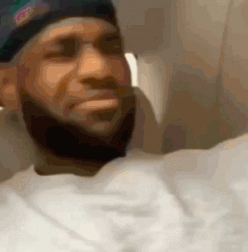 A Blurry Picture Of A Man With A Beard Wearing A Hat That Says ' Nba ' On It GIF