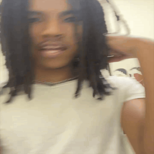 A Blurry Picture Of A Man With Dreadlocks GIF