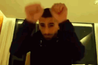A Blurry Picture Of A Man With His Hands Up In The Air GIF