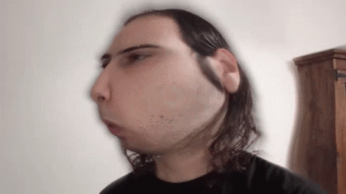 A Blurry Picture Of A Man With Long Hair And A Beard GIF