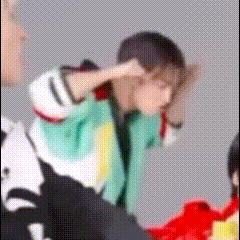 A Blurry Picture Of A Person Covering Their Ears With Their Hands . GIF