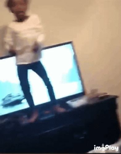 A Blurry Picture Of A Person Dancing In Front Of A Tv GIF
