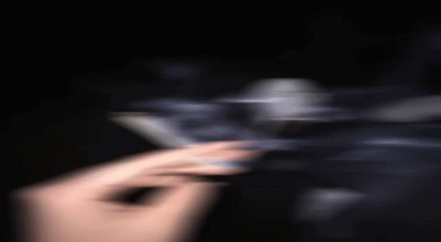 A Blurry Picture Of A Person Holding A Cigarette In Their Hand . GIF