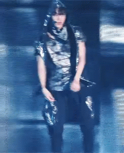 A Blurry Picture Of A Person Holding A Microphone In A Dark Room GIF