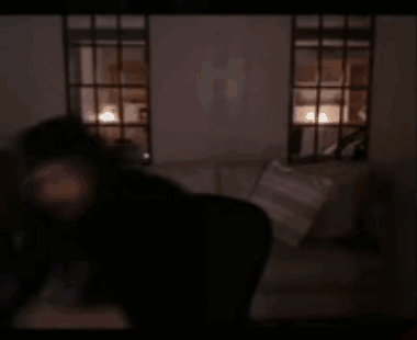 A Blurry Picture Of A Person Holding A Remote Control In A Dark Room . GIF