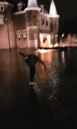 A Blurry Picture Of A Person In A Flooded Area At Night GIF