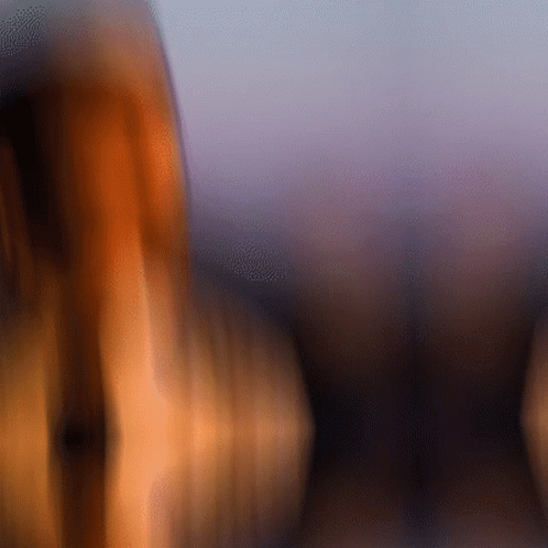 A Blurry Picture Of A Person 'S Face With A Purple Sky In The Background GIF