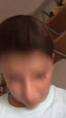 A Blurry Picture Of A Person 'S Face With A White Shirt On GIF